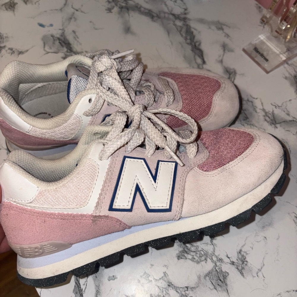 Pink and white New Balance 574 shoes